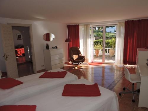 a bedroom with two beds and a chair and a patio at Nerja Villas-Capistrano in Nerja