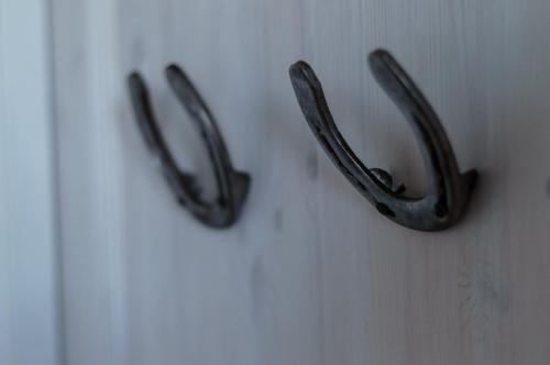 two metal antlers are hanging on a wall at Akurgerði Guesthouse 8 - Country Life Style in Ölfus