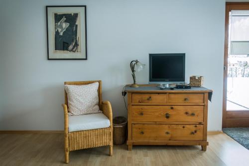 Cette chambre dispose d'une commode, d'une télévision et d'une chaise. dans l'établissement ferienwohnung Gabriele, à Schönau am Königssee