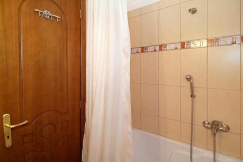 a bathroom with a shower curtain and a tub at Hotel Varonos in Delfoi