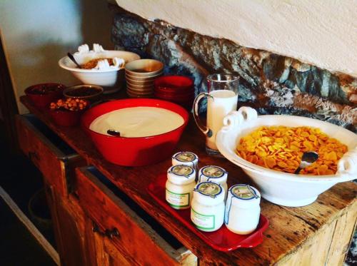 a table with a bowl of food and jars of milk at Agriturismo Treterre in Pianello Del Lario