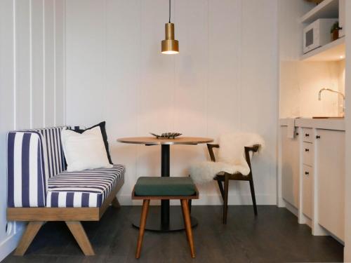 ein Wohnzimmer mit einem Tisch und einem Stuhl in der Unterkunft Getaway Studios "The Providence" Oostende in Ostende