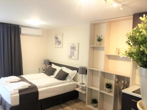 a bedroom with a large white bed and shelves at Sky Apartments in Blagoevgrad