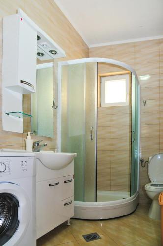 a bathroom with a shower and a washing machine at Apartmani Bulajic in Tivat