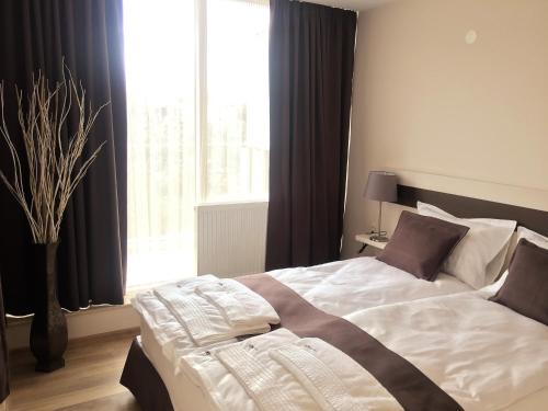 a bedroom with a large bed in front of a window at Sky Apartments in Blagoevgrad