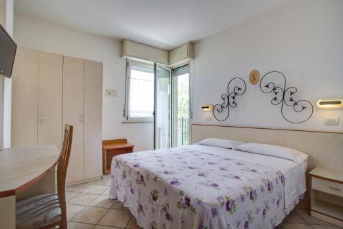 a bedroom with a bed and a table and a table and a tableablish at Ancora Hotel & Residence in Cattolica