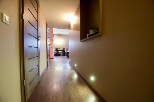 a hallway with a door and a room with a table at 7 Koron - Exclusive Apartments in Kraków