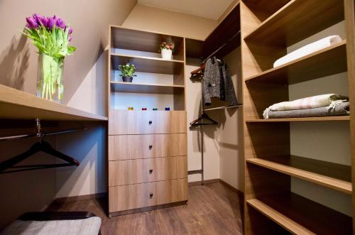a walk in closet with wooden shelves and a vase of flowers at 7 Koron - Exclusive Apartments in Kraków