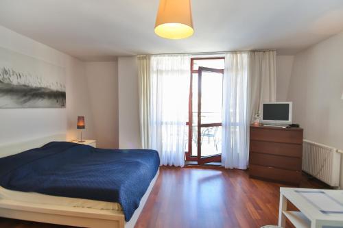 Schlafzimmer mit einem Bett, einem TV und einem Fenster in der Unterkunft Apartamenty Świnoujście - Róża Wiatrów in Świnoujście