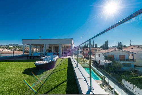 a house with a boat on the grass on a balcony at Hotel Villa Katy in Bardolino