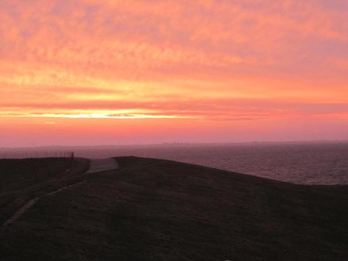 a sunset on top of a hill with the ocean at Hotel Möllner Hof in Welt