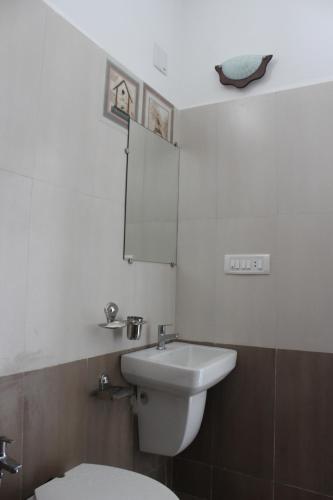 a bathroom with a white toilet and a sink at Little Rann Resort in Zainābād