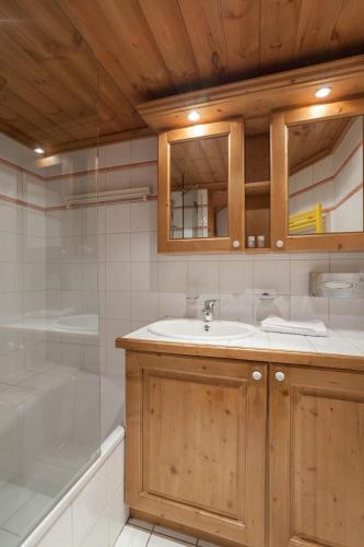 une salle de bain avec un lavabo, une douche et une baignoire dans l'établissement Résidence Pierre & Vacances Premium La Ginabelle, à Chamonix-Mont-Blanc