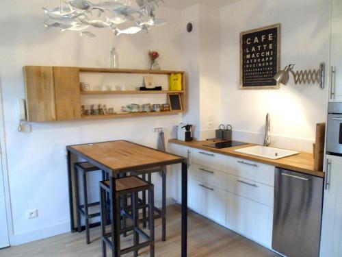 a small kitchen with a table and a sink at L' Appart du Marché in La Rochelle