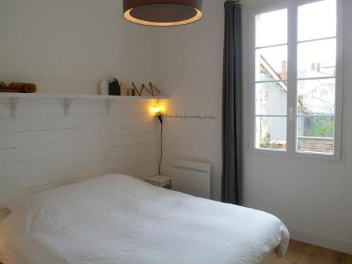 a bedroom with a white bed and a window at L' Appart du Marché in La Rochelle