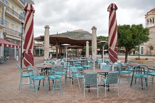 a group of tables and chairs with umbrellas at Morfeas Hotel in Argos