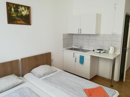 a small kitchen with two beds and a sink at Capital Guesthouse Budapest in Budapest