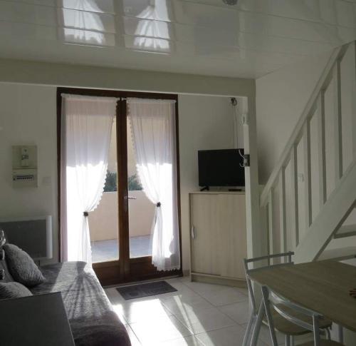 uma sala de estar com uma porta de vidro deslizante e uma televisão em Maisonnette 4 personnes Port Leucate 4HAW444 em Leucate