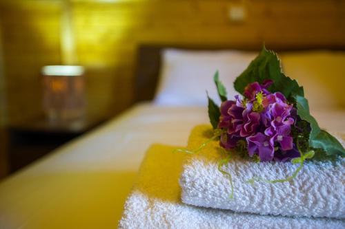 a bouquet of purple flowers sitting on top of towels at Ricky Chalet Near Troodos in Spilia
