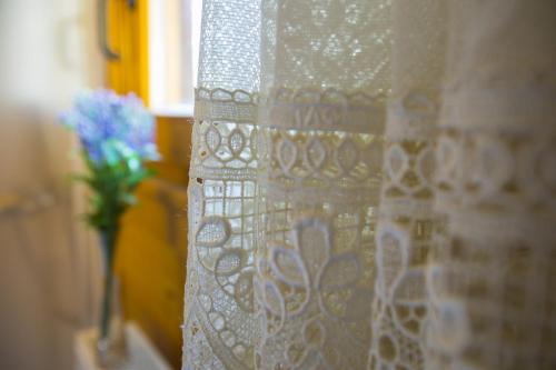 a white curtain with a vase of flowers on a window at Ricky Chalet Near Troodos in Spilia