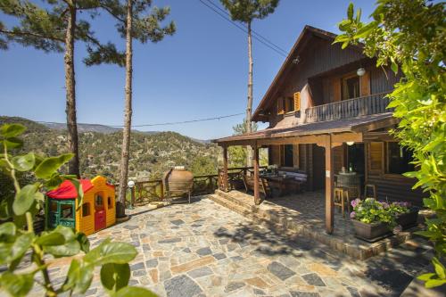 a house with a playground on a patio at Ricky Chalet Near Troodos in Spilia