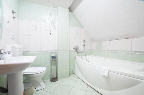 a bathroom with a tub and a toilet and a sink at Hotel Filipov in Kochani