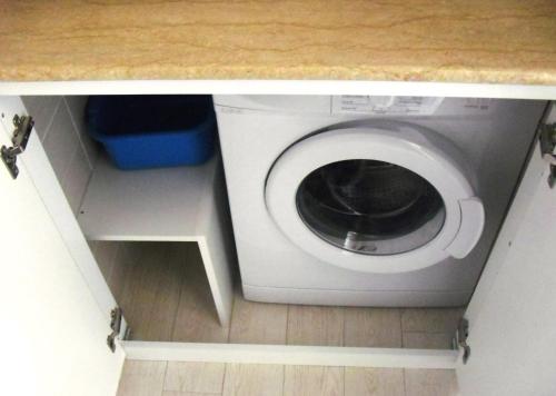 a washing machine in a kitchen under a counter at La Casa del Mare in Sperlonga