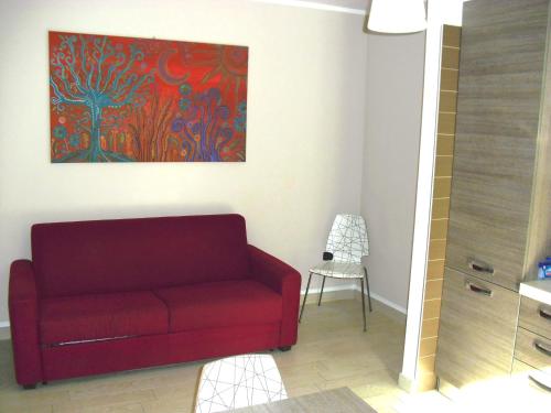 a red couch in a living room with a painting at La Casa del Mare in Sperlonga