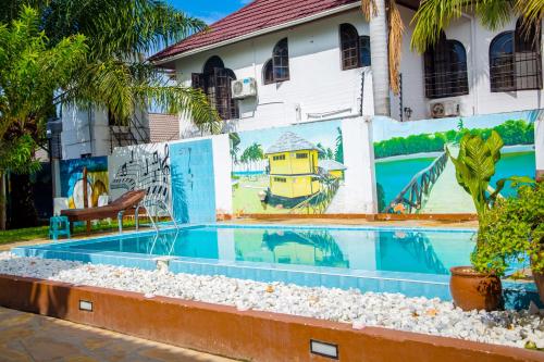 a swimming pool with a mural on the side of a building at Saadani Tourist Center - Hostel in Dar es Salaam