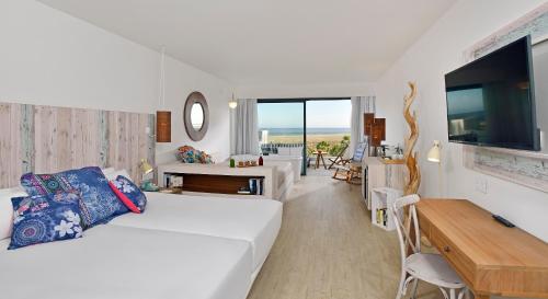 een witte kamer met een bed en een eetkamer bij INNSiDE by Meliá Fuerteventura – Adults Only in Costa Calma