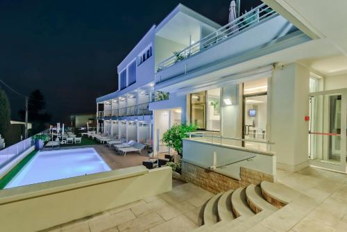 an exterior view of a house with a swimming pool at Hotel Villa Katy in Bardolino