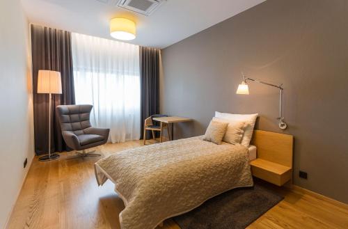 ein Hotelzimmer mit einem Bett und einem Stuhl in der Unterkunft Vinařství Obelisk in Valtice