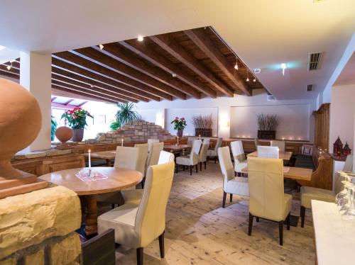 a restaurant with tables and chairs in a room at Alpinresort ValSaa - Sport & Spa in Saalbach Hinterglemm