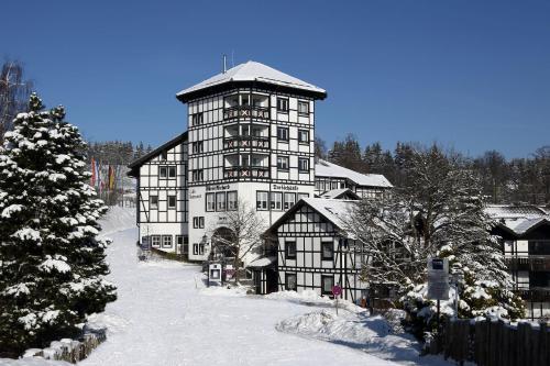 ein großes Gebäude im Schnee mit einem Weihnachtsbaum in der Unterkunft Dorint Resort Winterberg in Winterberg