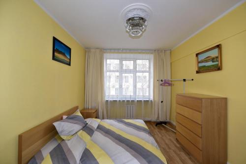a bedroom with a bed and a window and a dresser at T apartment in Ulaanbaatar