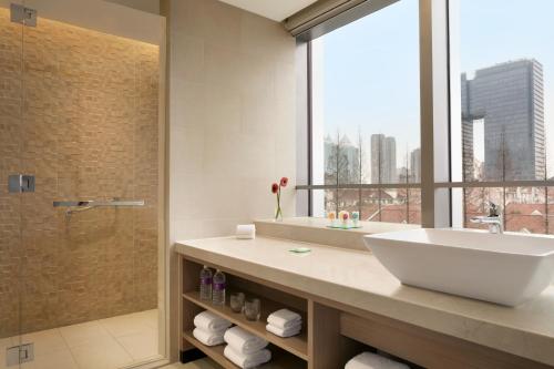 a bathroom with a sink and a shower with a window at Hyatt Place Shanghai Tianshan Plaza in Shanghai