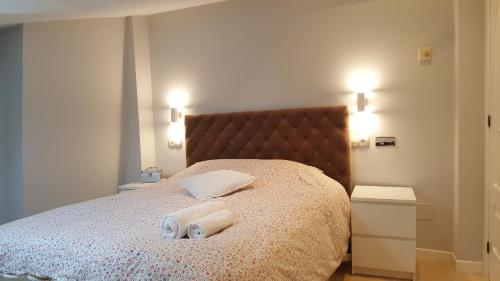 een slaapkamer met een bed met twee handdoeken erop bij 3M in Gijón