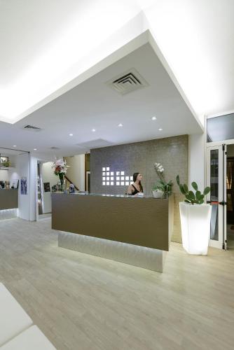 a woman sitting at a counter in a lobby at Hotel Villa Katy in Bardolino