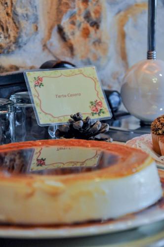 einen Tisch mit einem Teller Essen und einem Kuchen in der Unterkunft Posada La Cotía in Helguera