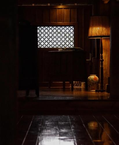 a dark room with a window and a lamp at You Ran Tai in Jinghong