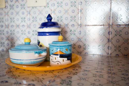 two vases sitting on a plate on a counter at Case Cincotta- Agliozzo in Lipari