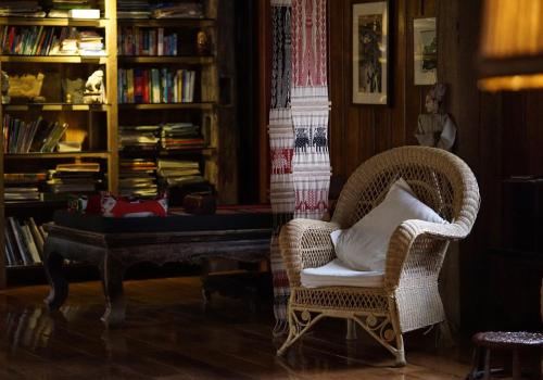 a living room with a chair and a piano at You Ran Tai in Jinghong