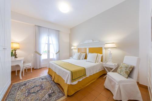 a bedroom with a bed and a chair and a table at Villa Romana Hotel & Spa in Minori