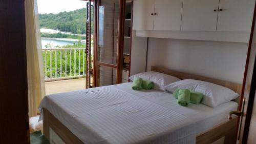 ein Schlafzimmer mit einem Bett mit zwei grünen Kissen in der Unterkunft Podaca house in Podaca