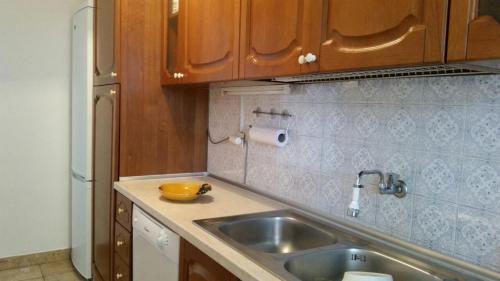 a kitchen with a sink and wooden cabinets at Podaca house in Podaca