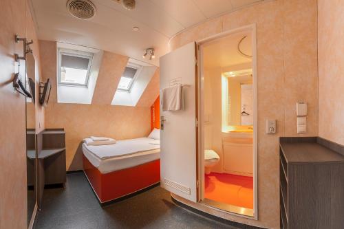 a hotel room with a bed and a dresser at easyHotel Budapest Oktogon in Budapest