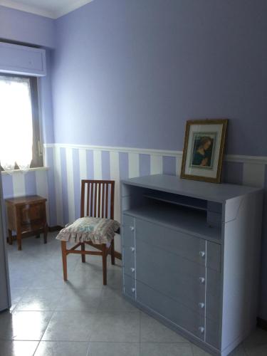 a blue room with a dresser and a chair at La Casetta al mare in Nettuno
