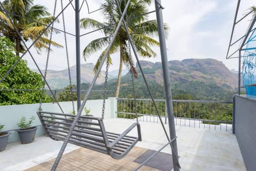 a hammock on a balcony with a view of mountains at Sceva's Garden Home in Munnar