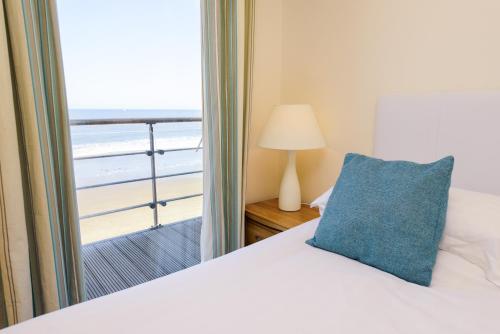 a bedroom with a bed with a blue pillow and a window at The Sands Sea Front Apartments in Scarborough