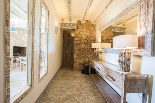 a room with a stone wall and a table with a lamp at Mas del Sord 1335 in La Selva del Camp